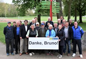 Menschengruppe am Sportplatz Sentruper Höhe mit Banner auf dem "Danke, Bruno" steht