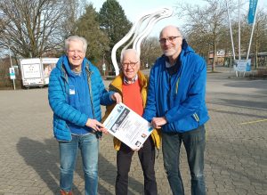 Zoolauf Münster 2023: Die Veranstalter vor dem Allwetterzoo mit Plakat in der Hand
