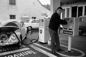 historische schwarz-weiß Fotografie: Preußen-Spieler betankt seinen Wagen