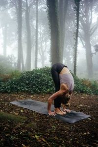 Symbolbild Klima-Training: Frau mit Yogamatte im Wald