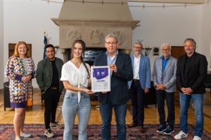 Host Town: Alina Niessner von den Special Olympics NRW übergibt eine Urkunde an Rainer Bergmann vom Sportamt der Stadt Münster.